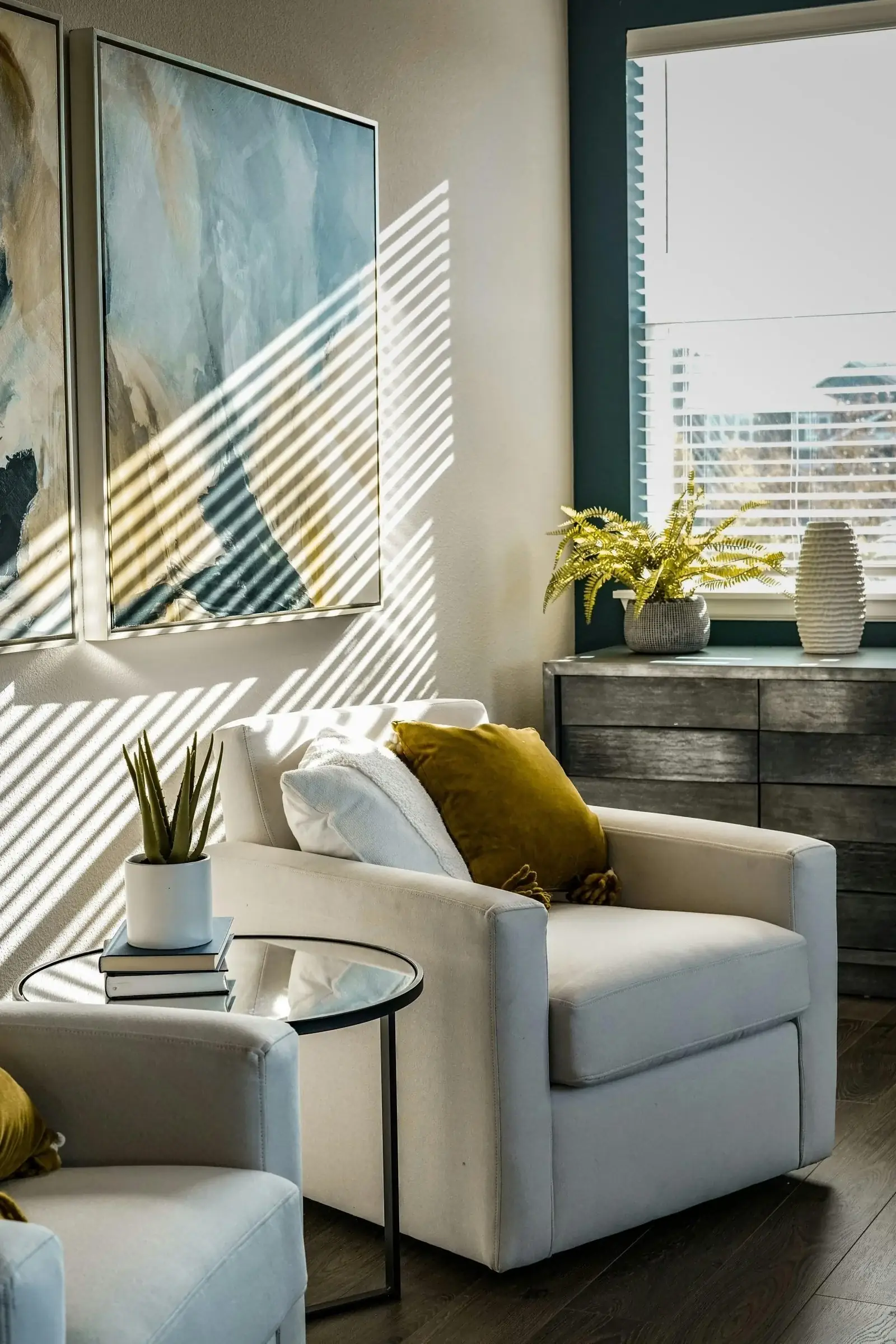 A warm consultation room with an armchair, plants, and sunlight through blinds.