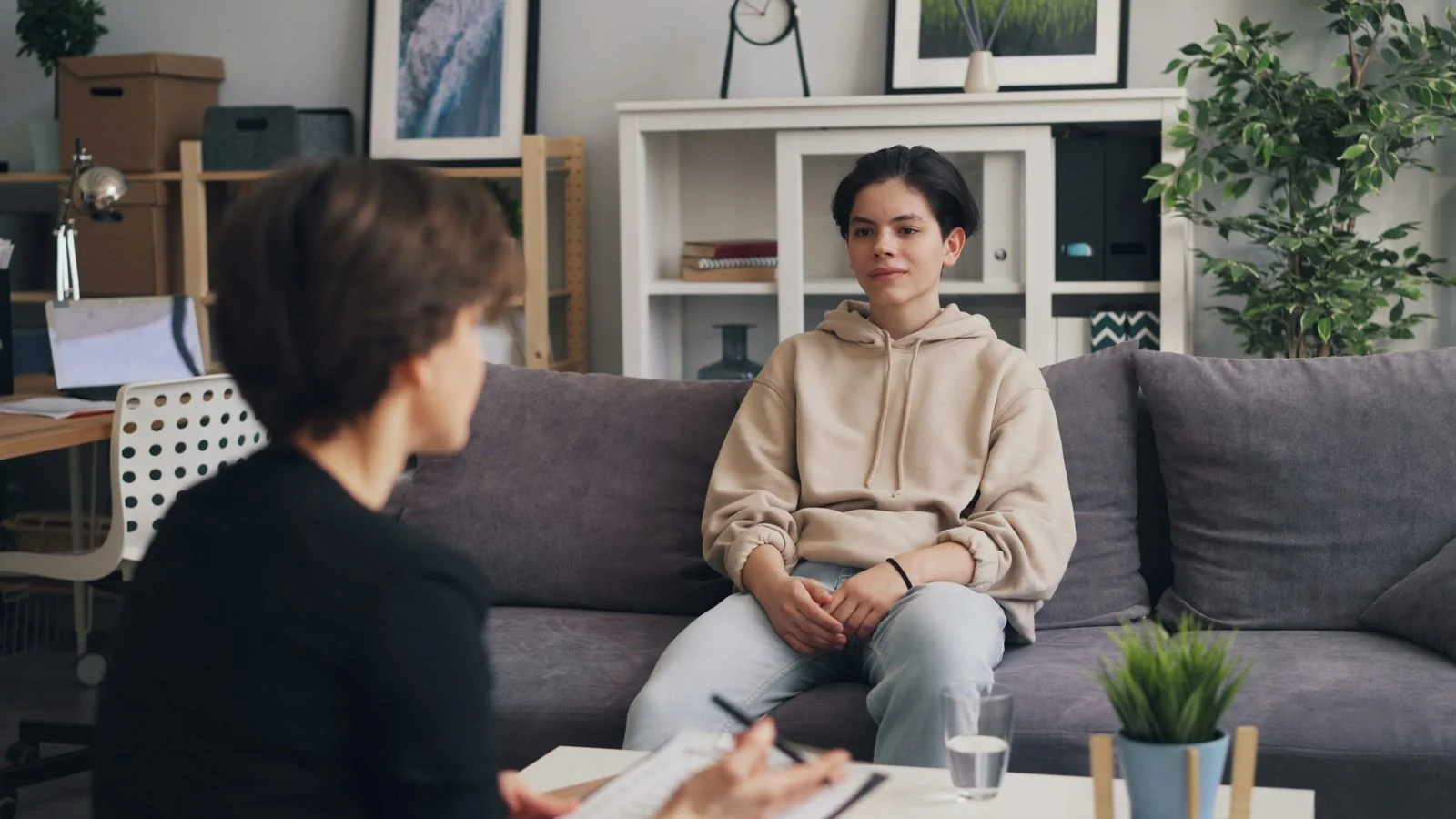 A therapist's office with a client seated on a couch.